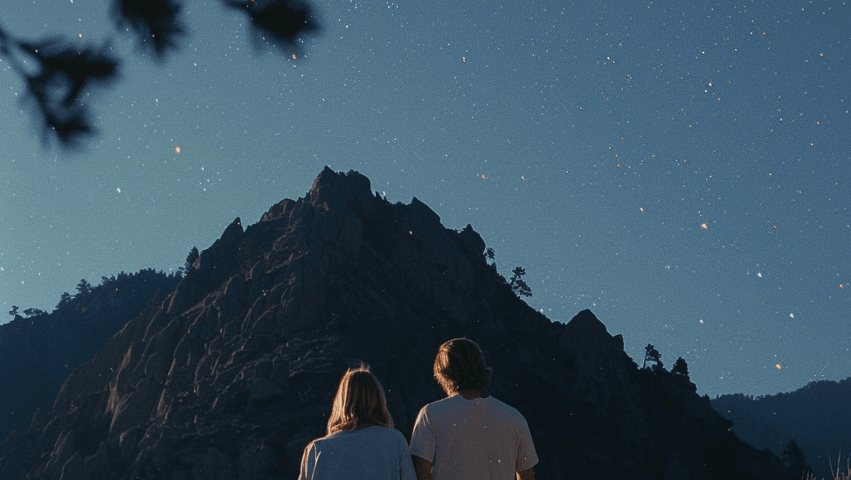 Two people look up at a hill and the evening sky.